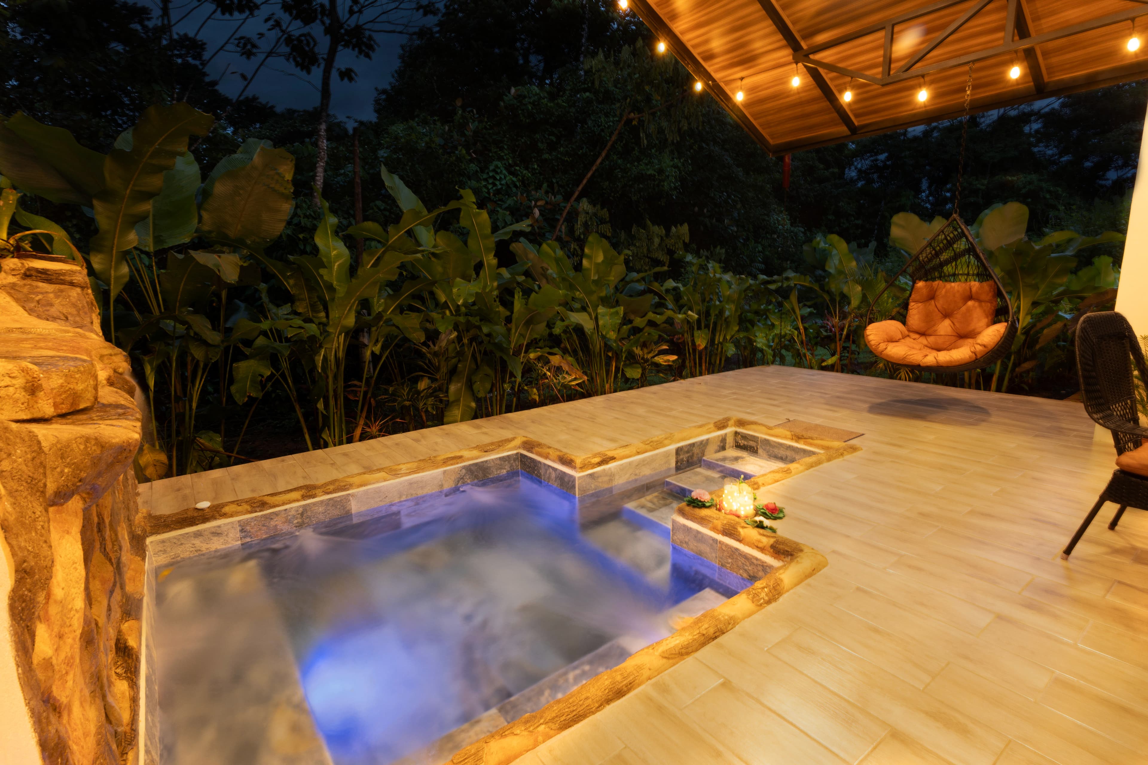 Jacuzzi privado iluminado frente al bosque tropical